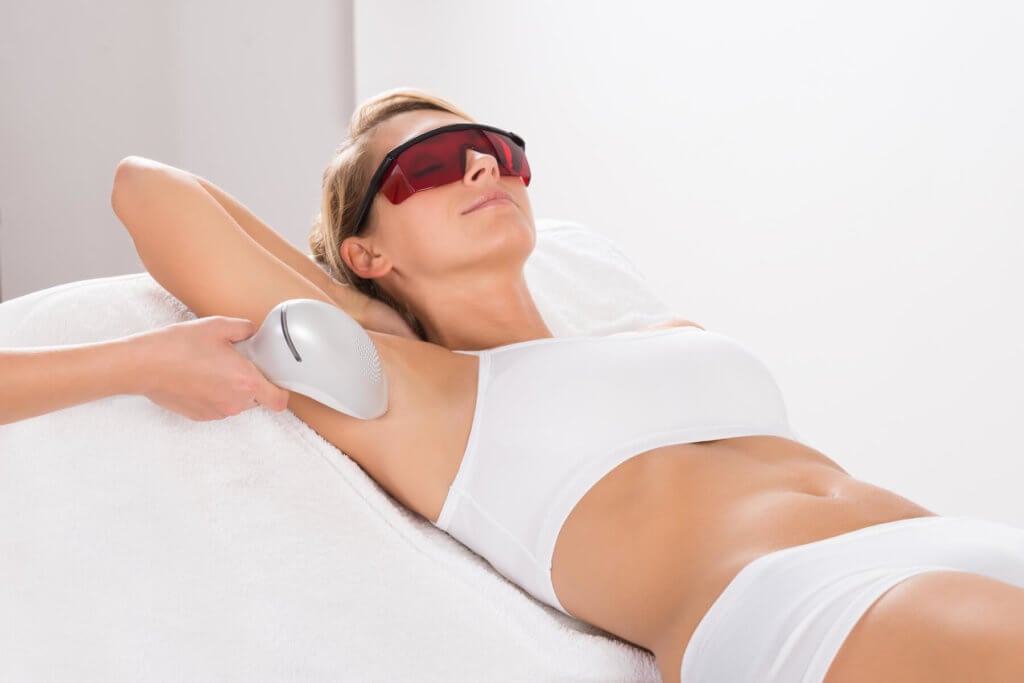 A woman receiving laser hair removal on her underarms.